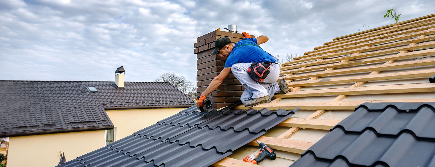 A man installs metal roofing on a house, demonstrating skilled craftsmanship and safety on the rooftop.